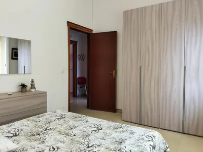 a bedroom with a bed and a wooden cabinet at Casa Le Bellezze del Golfo in Castellammare del Golfo