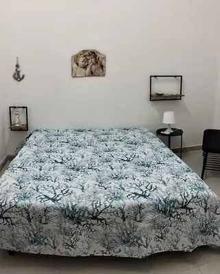 a bedroom with a bed with a blue and white bedspread at Casa Le Bellezze del Golfo in Castellammare del Golfo