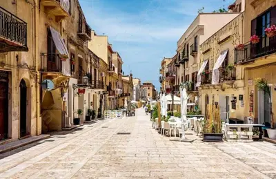 an empty street in a town with tables and chairs at Casa Le Bellezze del Golfo in Castellammare del Golfo