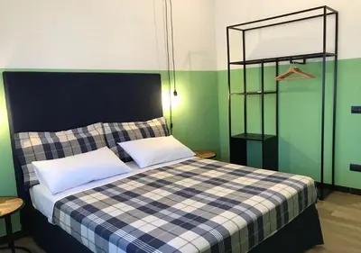 a bed with two pillows in a room with green walls at NA' SCICCHERIA HOME in Castellammare del Golfo