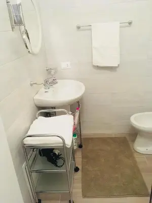 a white bathroom with a sink and a toilet at Around Cassaro Holiday House in Palermo