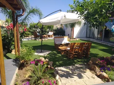 a patio with a table and chairs and an umbrella at L'isola del sole in Castelluzzo
