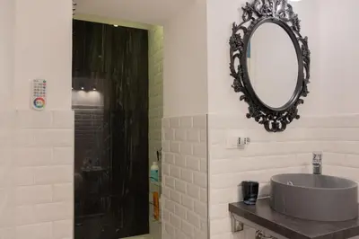 a bathroom with a sink and a mirror and a shower at Al teatro Massimo in Palermo