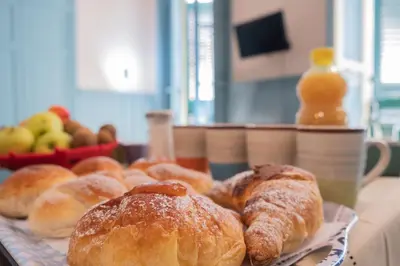 a tray of pastries on a table with a plate of bread at Al teatro Massimo in Palermo