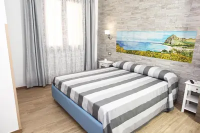 a bedroom with a bed and a painting on the wall at Ninni e Fede in San Vito lo Capo