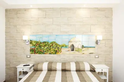 a bedroom with a painting on a brick wall at Ninni e Fede in San Vito lo Capo