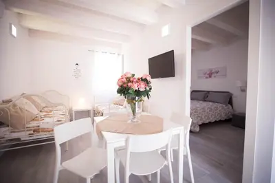 a room with a table with a vase of flowers on it at Sciabika Home - Edificio Eolie in Castellammare del Golfo