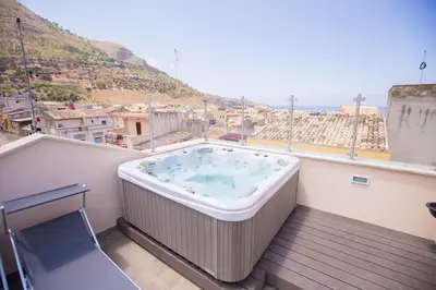 a hot tub on a balcony with a view of a city at Sciabika Home - Edificio Eolie in Castellammare del Golfo