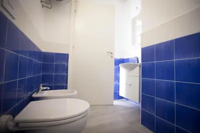 a blue and white bathroom with a toilet and a sink at Sciabika Home - Edificio Eolie in Castellammare del Golfo