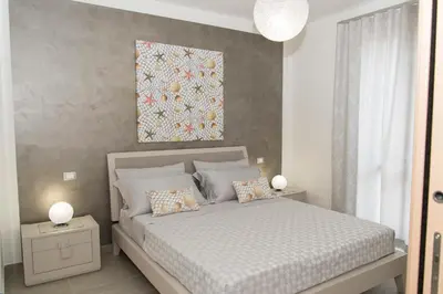 a bedroom with a bed and a painting on the wall at Casa Vacanze Fontana in San Vito lo Capo