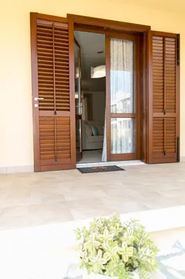 a door to a house with a plant in front of it at Casa Vacanze Fontana in San Vito lo Capo