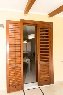 a wooden door leading to a room with a table at Casa Vacanze Fontana in San Vito lo Capo