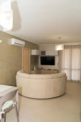 a living room with a large couch and a tv at Casa Vacanze Fontana in San Vito lo Capo