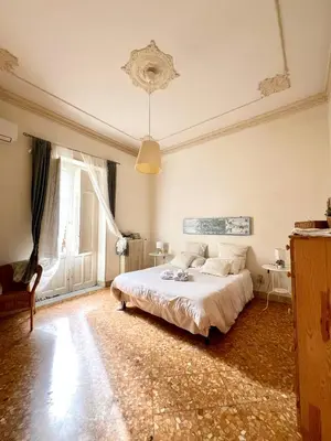 a bedroom with a bed and a table and a window at Casa Jolanda B&B in Palermo