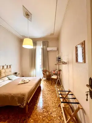 a bedroom with a bed and a table and a chair at Casa Jolanda B&B in Palermo