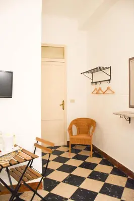 a room with a chair and a checkered floor at Casa Jolanda B&B in Palermo