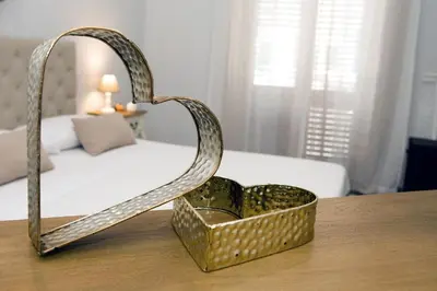 a metal heart shaped basket on a table in a bedroom at Reginella B&B Palermo in Palermo