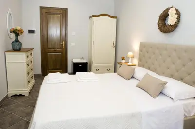 a bedroom with a large white bed and a dresser at Reginella B&B Palermo in Palermo