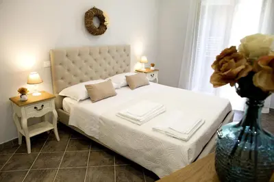 a bedroom with a white bed with a vase of flowers at Reginella B&B Palermo in Palermo