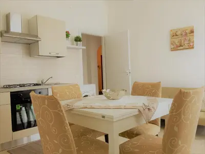 a kitchen with a white table and chairs and a table and a kitchen sidx sidx at Appartamento al centro vicino il porto in Palermo