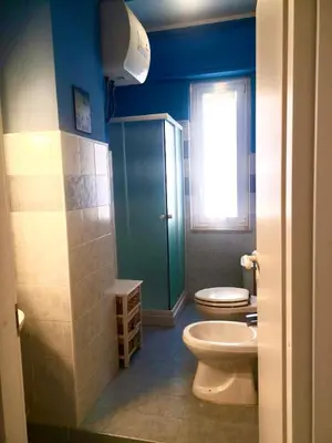 a bathroom with a toilet and a window at Appartamento al centro vicino il porto in Palermo