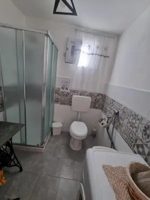 a bathroom with a shower and a toilet and a tub at Casa turiddu Makari in Castelluzzo