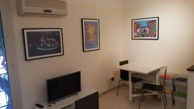 a room with a table and a tv and a desk at Le Stelle del Massimo in Palermo