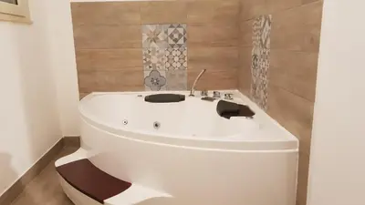 a white bath tub in a bathroom with tiles at Le Stelle del Massimo in Palermo