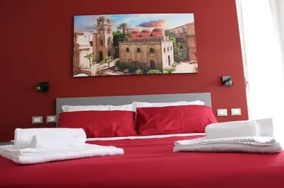 a red and white bed with red pillows on it at B&B D'Amari Affittacamere in Palermo