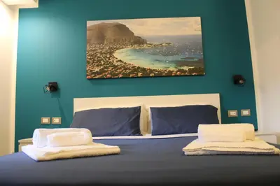 a bedroom with a bed with a painting on the wall at B&B D'Amari Affittacamere in Palermo