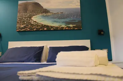 a bedroom with a bed with a picture on the wall at B&B D'Amari Affittacamere in Palermo
