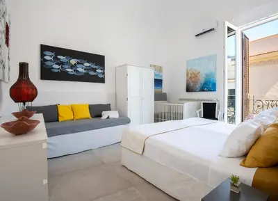 a white bedroom with a bed and a couch at Casa Madonia in Terrasini