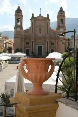 a vase sitting on a ledge in front of a church at Casa Madonia in Terrasini