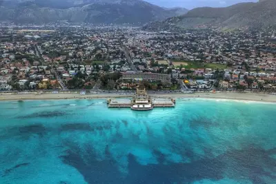 an aerial view of a beach with a boat in the water at la petit maison in Palermo