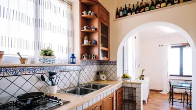 a kitchen with a sink and a counter with a window at Villa Zabbara Capo Zafferano in Bagheria