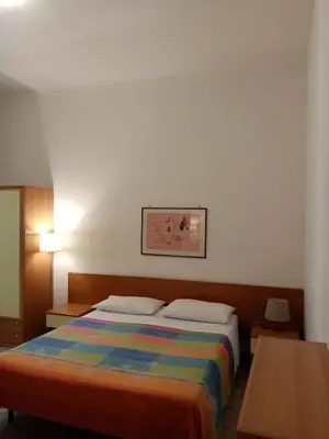 a bedroom with a bed with a colorful blanket at Ariston Petit Hotel in Palermo