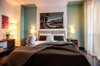 a bedroom with a large bed with a painting on the wall at Hotel Pocho in San Vito lo Capo