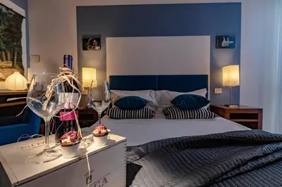 a bedroom with a king sized bed with blue walls at Hotel Pocho in San Vito lo Capo