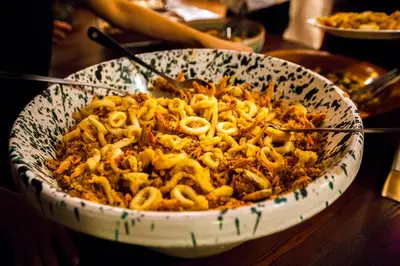 a bowl of food with noodles in it on a table at Hotel Pocho in San Vito lo Capo
