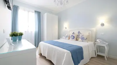 a white bedroom with a bed and a window at La Via dell'Acqua in Macari