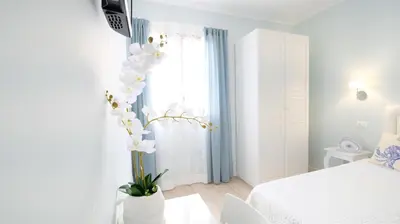 a white bedroom with a bed and a window at La Via dell'Acqua in Macari