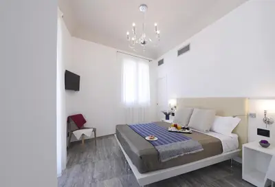 a bedroom with a large bed and a chandelier at Best Western Hotel Principe di Lampedusa in Palermo