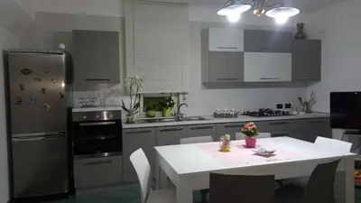a kitchen with a white table and a refrigerator at A casa di Elena in Alcamo