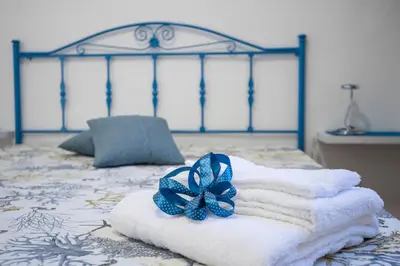 a pile of towels with a blue bow on a bed at Casa vacanze Mare Nostrum in Castellammare del Golfo