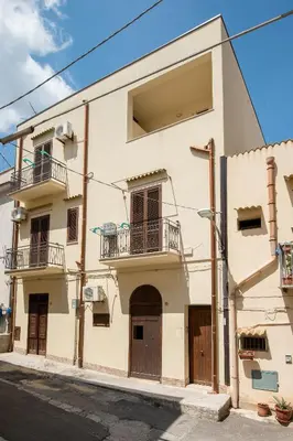 a white building with two balconies on a street at Casa vacanze Mare Nostrum in Castellammare del Golfo