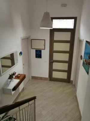 a hallway with a wooden door and a staircase at I Paesaggi in Castellammare del Golfo