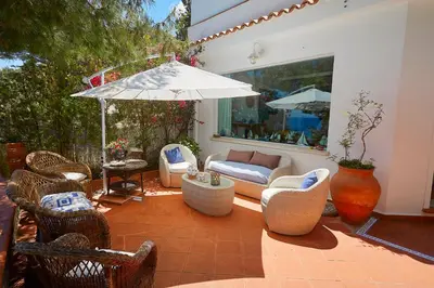 a patio with wicker chairs and an umbrella at Villa Gabry in Bagheria