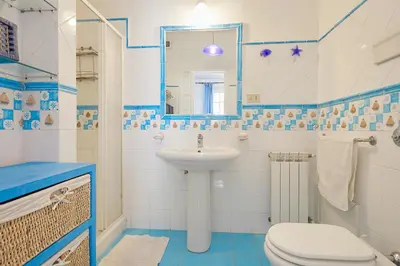a blue and white bathroom with a sink and a toilet at Villa Gabry in Bagheria