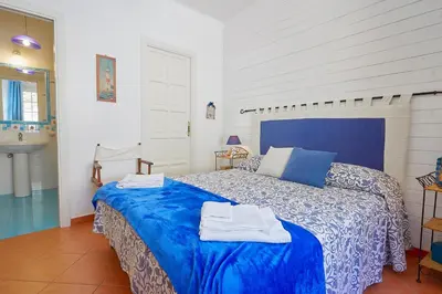 a bedroom with a blue bed and a sink at Villa Gabry in Bagheria