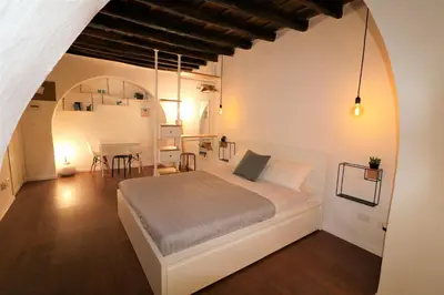 a white bedroom with a bed and a table at Palermo Home White Home in Palermo